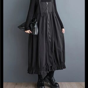 Retro look black jumper with black suspenders.  Very chic